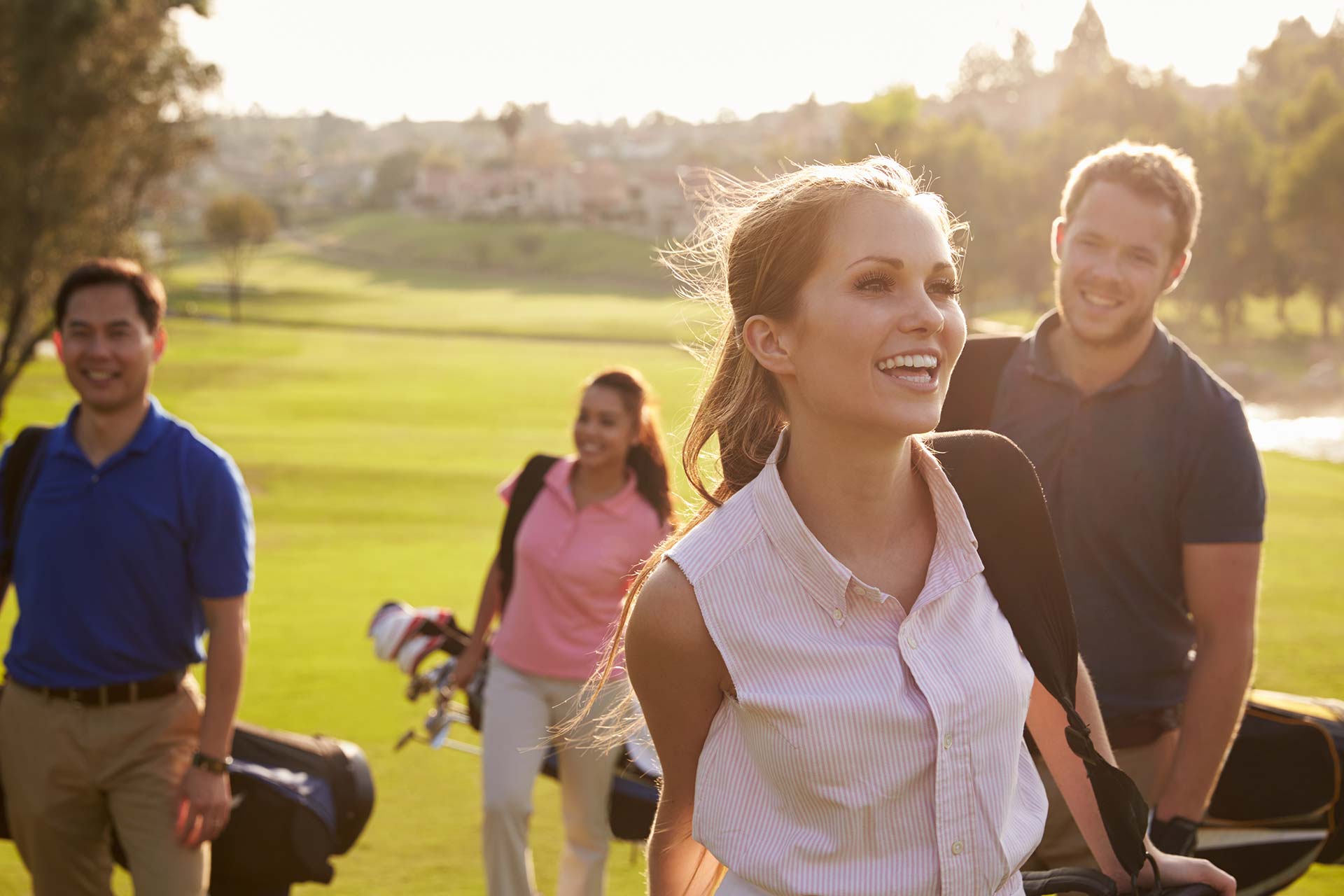 Golf tour group walking a fairway with travel bags